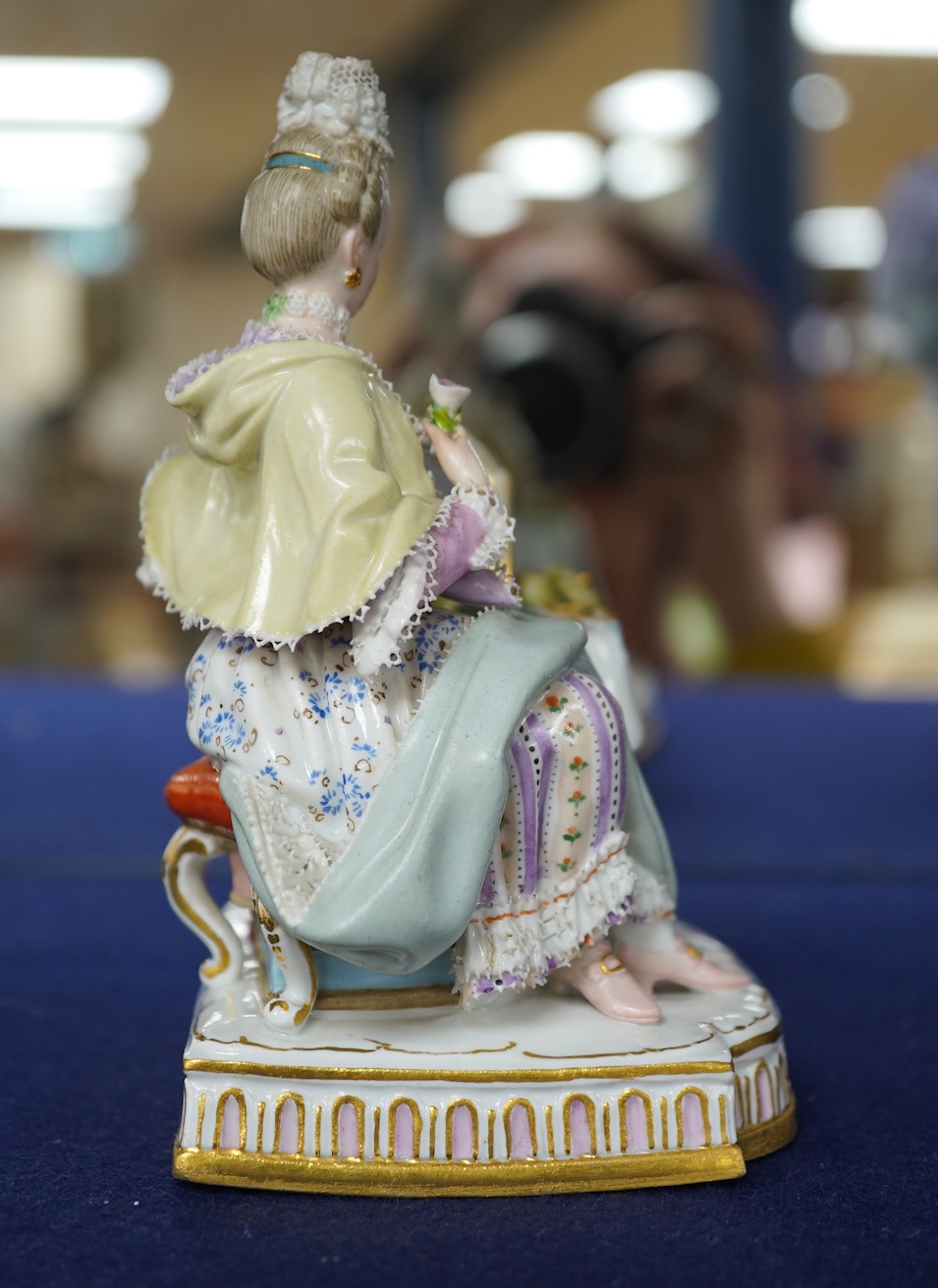 A late 19th century Meissen figure of Sight, from the Senses, a seated lady at her dressing table, crossed swords mark and incised E3 mark to base, 14cm high